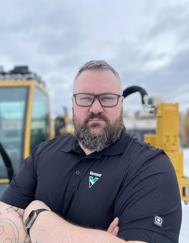 David Holland, Vermeer Mountain West branch manager in Anchorage, AK standing in front of Vermeer machinery.